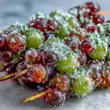 Sweet-tart frozen grape skewers coated in fragrant lime sugar, perfect for cooling off on a hot day.