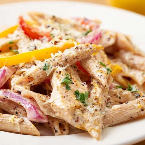 A close-up of Creamy Cajun Chicken Pasta Lite, featuring whole wheat penne tossed with tender chicken in a velvety reduced-fat Cajun cream sauce.  