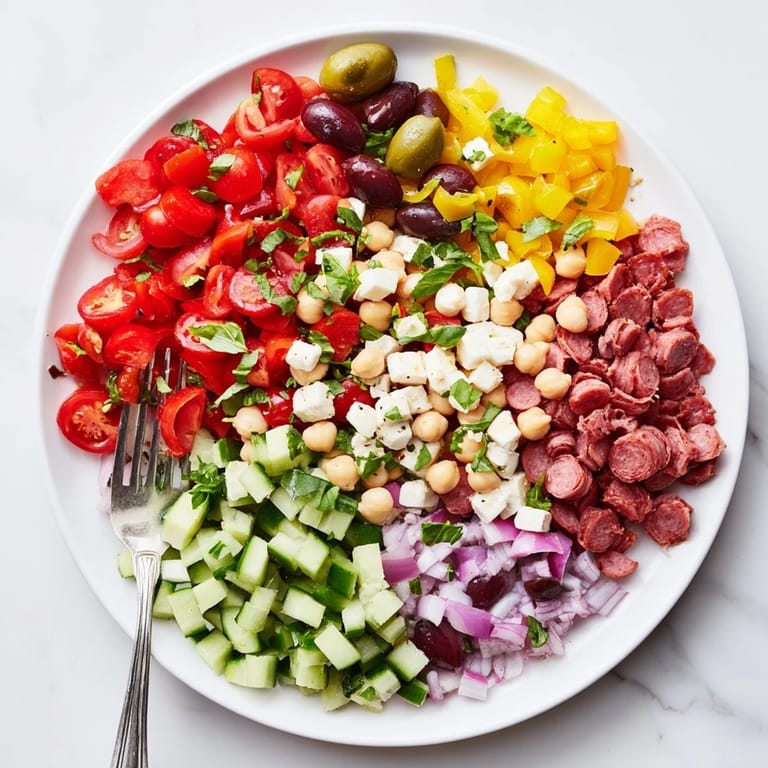 A close-up of Crunchy Antipasto Chopped Salad in a bowl, featuring colorful peppers, olives, and herbs for a fresh, satisfying bite.