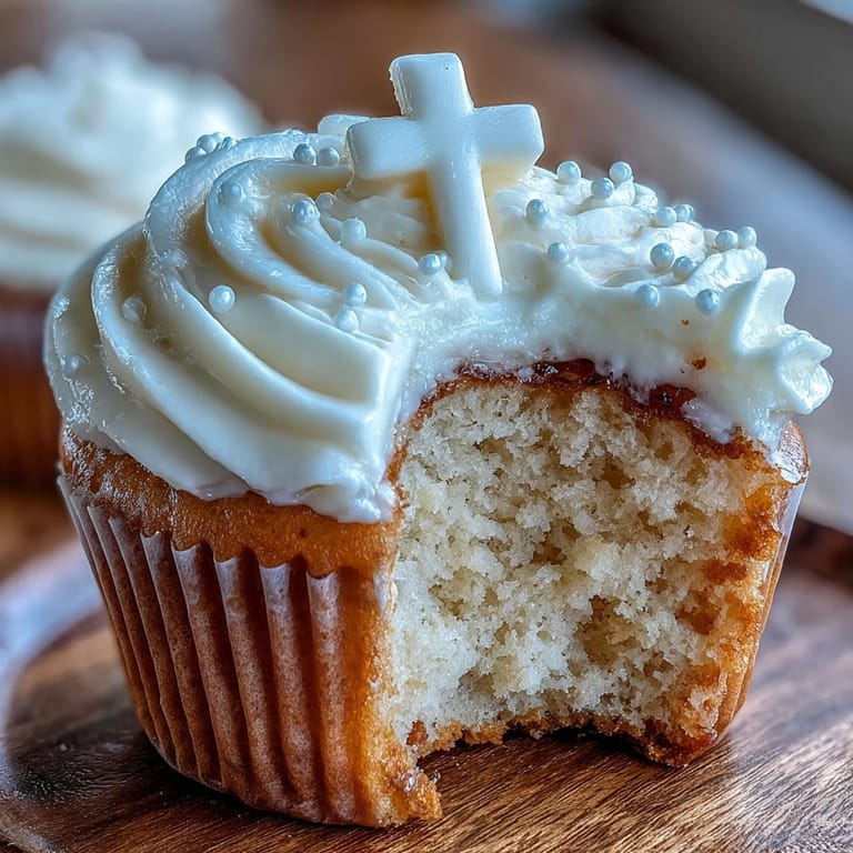 Showcasing tender communion cupcakes topped with sweet buttercream and a fondant cross.