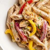 Creamy Cajun Chicken Pasta Lite with juicy chicken strips and colorful bell peppers in a light, spicy sauce served over penne.  