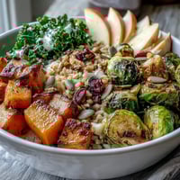 Fall Vegetable Bowl features roasted butternut squash and Brussels sprouts, with wilted kale and caramelized apples served over warm farro.