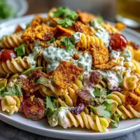 Creamy avocado ranch pasta salad with taco flavors and crunchy Doritos in a colorful bowl.