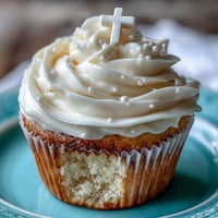 Communion cupcakes with white fondant cross: fluffy vanilla cake, creamy frosting.